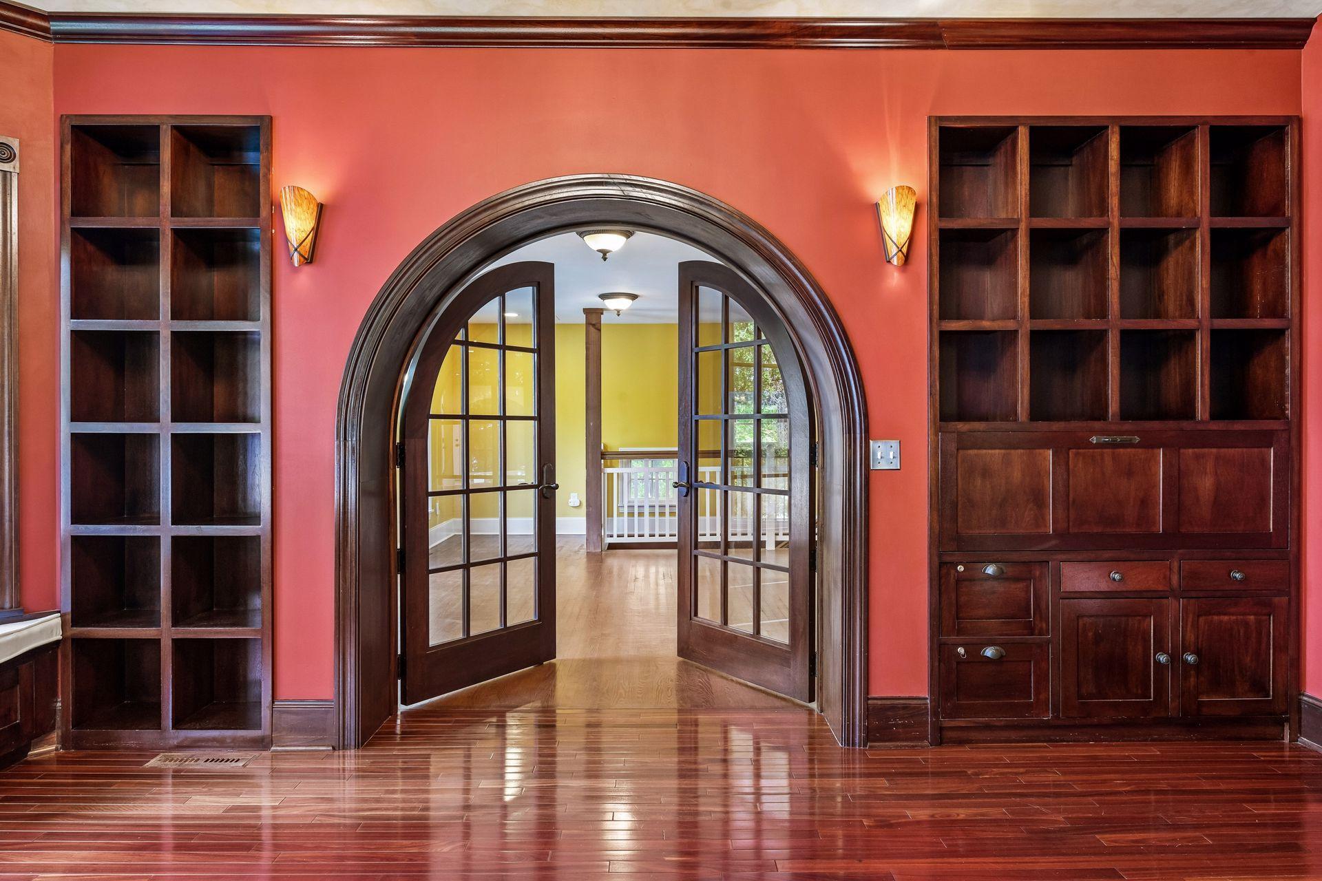 Beautiful architectural details and arched French doors lead into the office.