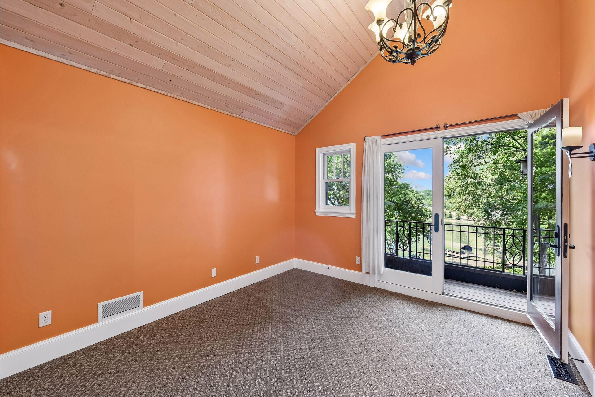 Upper-level primary bedroom with private lakeside balcony.