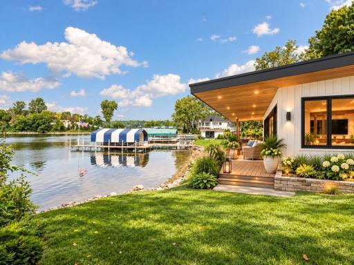 Lakeside boat house with 123' of sandy lakeshore. Your dock is with the blue and white canopy. AI Enhanced