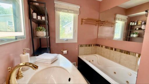 Elegant tiled tub surround with designer shelving. Soak worthy style in every detail.