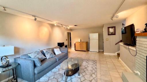 Cozy living area with tile flooring, versatile space for a rec room or den.