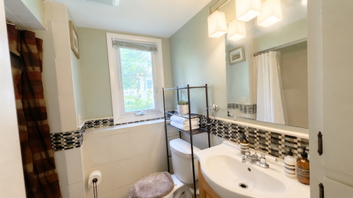 Full bath with practical storage shelving. Convenience meets comfort.