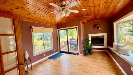 Vaulted wood ceilings in sunroom bring warmth to this cozy living space