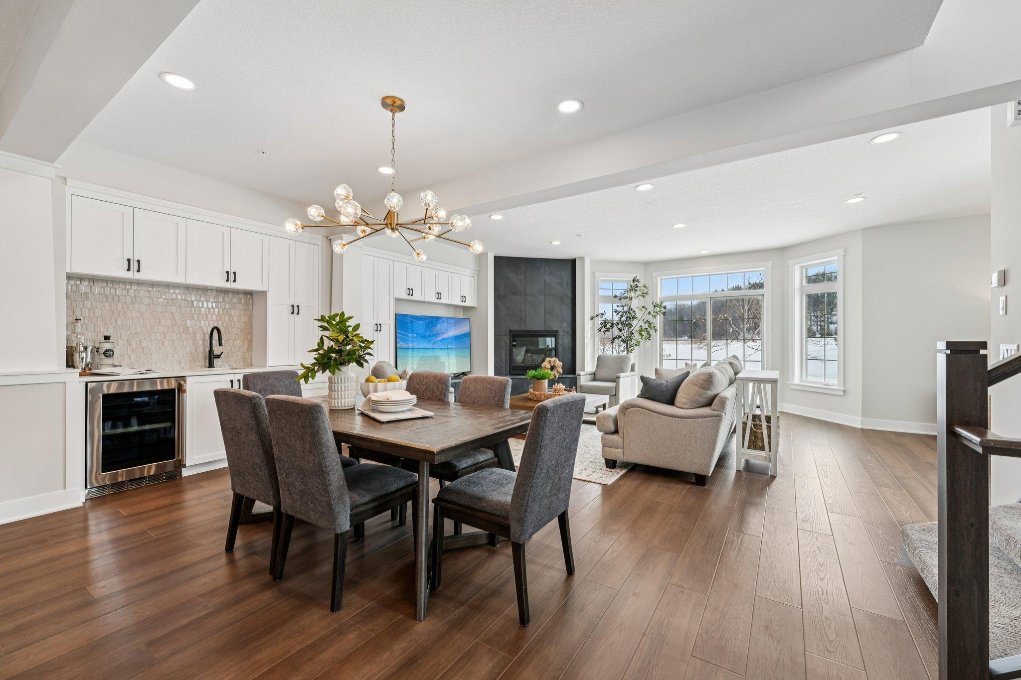 Open dining area with designer chandelier and hardwood floors, flowing seamlessly into the living space—ideal for hosting and everyday comfort.