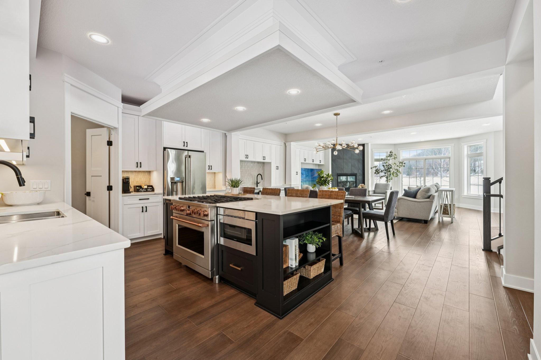 Chef-inspired kitchen featuring a large center island, quartz countertops, stainless steel appliances, and ample seating for casual dining.