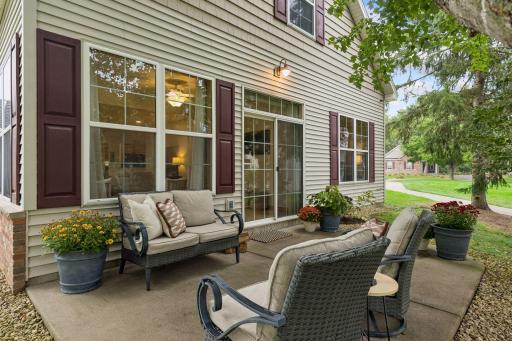 The patio has ample space for a grill and entertaining family and friends. It also wraps around to a large yard space with a gazebo for even more space to entertain. Note the windows and patio door that fill the interior with natural light.