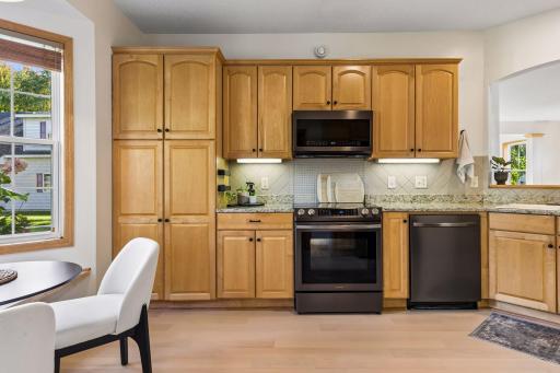 The updated kitchen has beautiful maple cabinetry, newer appliances, granite counter, and a tile backsplash.