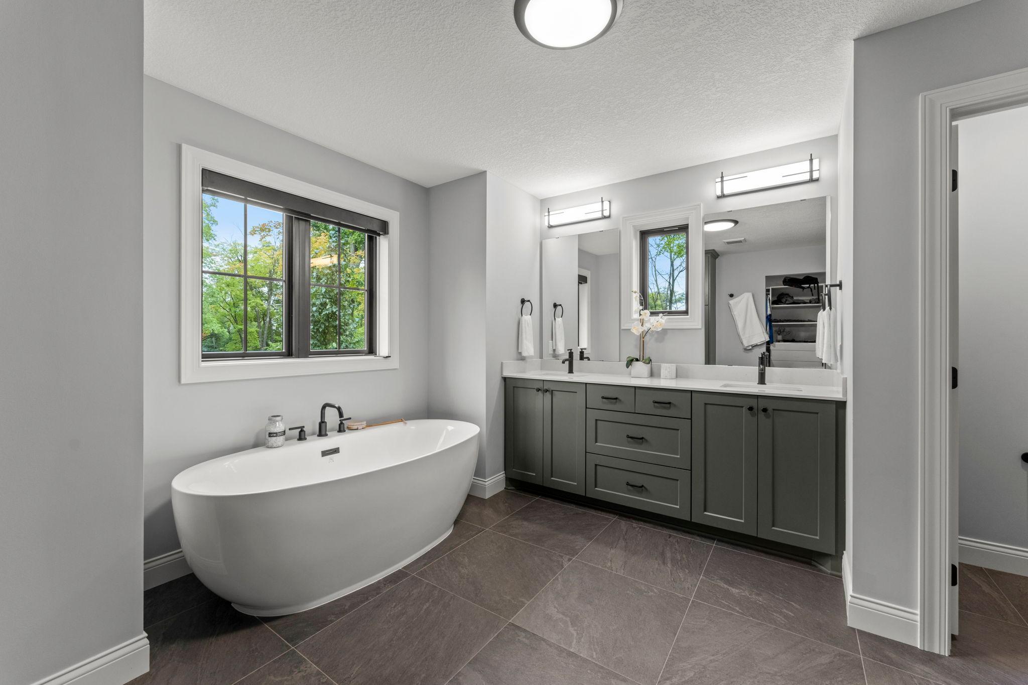 Owner's bath suite features a stand alone tub, walk in tile shower and walk-in closet