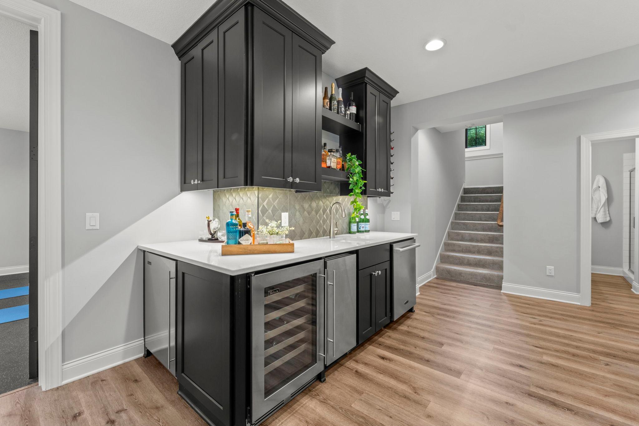 Wet bar features mini-fridge, wine fridge, ice maker and dishwasher
