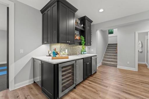 Wet bar features mini-fridge, wine fridge, ice maker and dishwasher