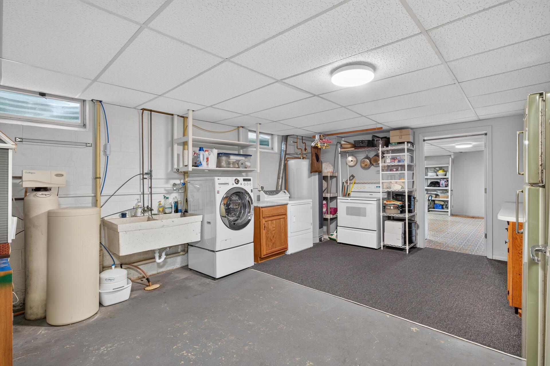 Spacious laundry room with an added stove/oven. Wonderful for hosted holidays meals!
