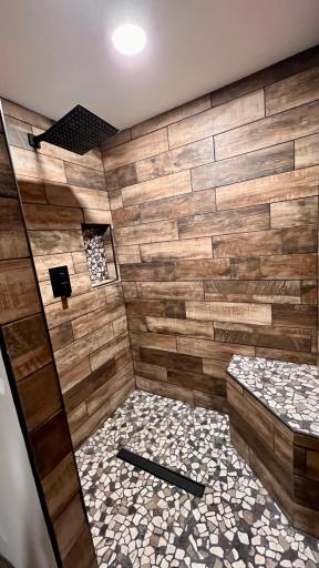 This beautiful tile and stone shower is located in the primary bedroom!