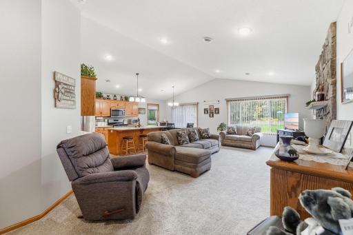 Sunlight floods the living space through expansive windows, offering picturesque, uninterrupted views of your private yard and the peaceful surrounding woods.