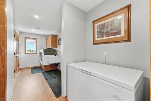 Laundry room features a coat closet, built in washer and dryer stand with cabinets above and utility sink. Exit to the right to the 3 car garage. Freezer nook could maintain its purpose as such or add a bench or lockers for a whole new aesthetic.