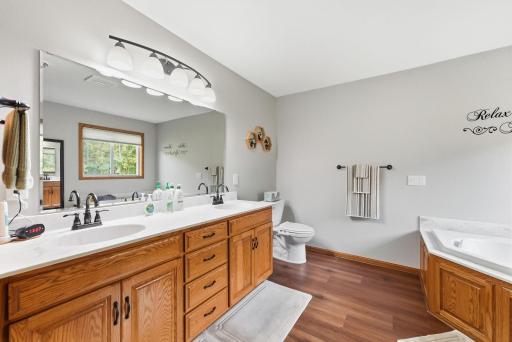 Your private oasis awaits. The primary suite boasts a lavish full bath with double sinks, a separate jetted soaking tub, and a pristine walk-in marble shower.