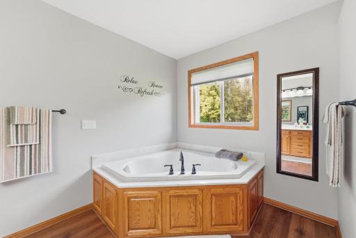 Indulge in evening relaxation from the jetted tub, beautifully positioned to capture twilight falling over the peaceful woods.