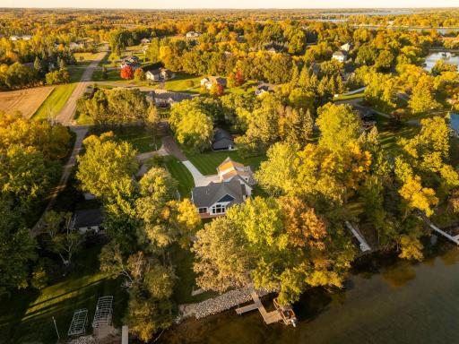 Escape to your own private lakeside oasis with this breathtaking waterfront estate, beautifully framed by a canopy of mature, vibrant autumn foliage.
