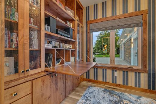Custom built desk-hickory cabinets, with shelves for a library and cabinets with rain glass for display plus motorized blinds for filtered light or privacy.