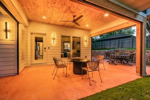 This spectacular, fully remote screened porch offers the perfect blend of indoor comfort and open-air relaxation. The gorgeous rich wood tongue-and-groove ceilings accented by the modern center fan and recessed lighting warms the space.