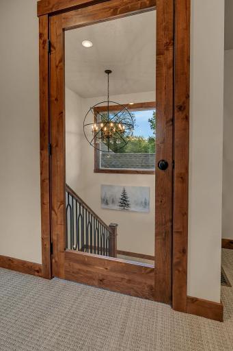 Glass-paneled door at top of stairs that leads to the bonus rooms.