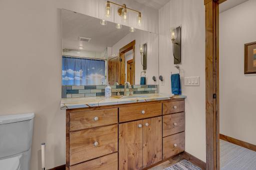 Large beautifully crafted vanity provides a excellent balance of traditional charm and modern convenience in addition to bright lights and nautical sconce.