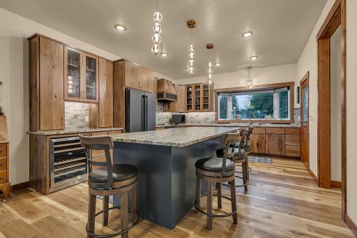 Custom hickory cabinets, Rain glass display cabinets, glass tiled backsplash with a touch of blue to tie the outside to the inside of the home.