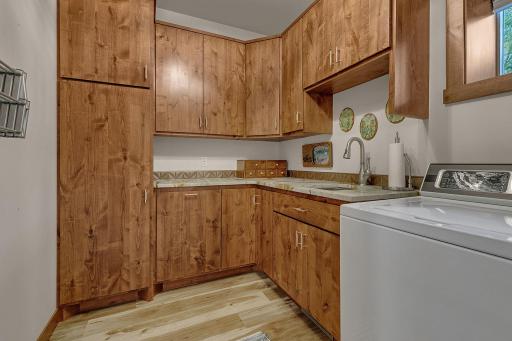 Functional design with built in drying rack and custom cabinets for hamper and storage, granite counter, stainless steel sink.
