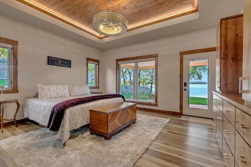 Step into this primary suite where luxury meets sophistication, custom ceiling insert with statement lighting and exterior door to screened patio.