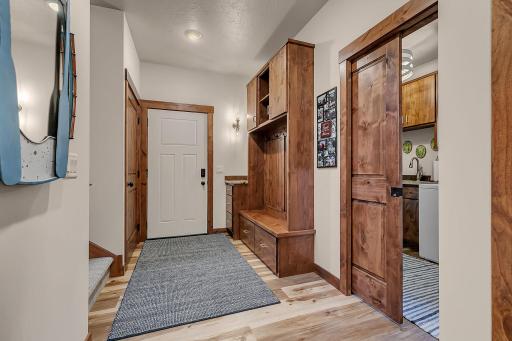 Door leads to garage, built in storage lockers, pocket door for laundry room.
