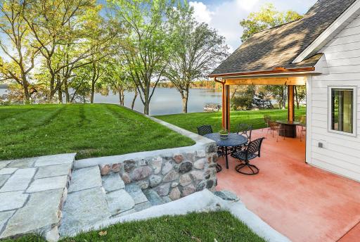 The lakeside yard boasts a beautifully terraced lawn with stone retaining wall and stairs to expansive to patio area.