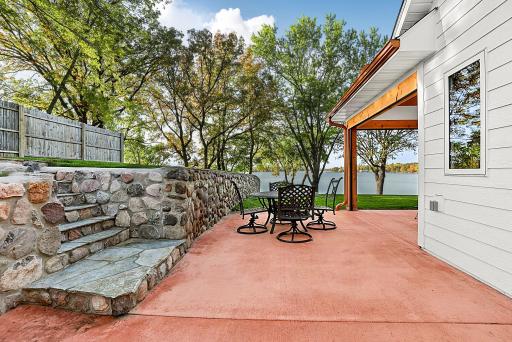 Enjoy great lake views and lots of room to entertain in this beautifully designed outdoor living space. Natural lake stone retaining wall adds timeless character and incorporates built-in stone steps that lead up to the elevated lawn.