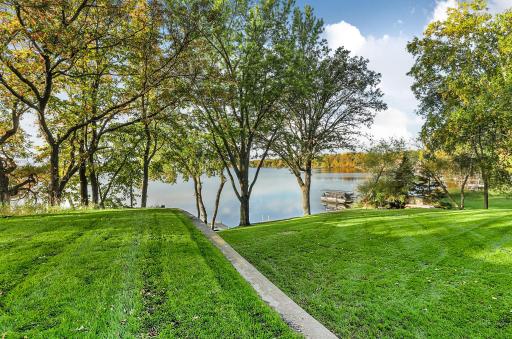 View of the lake from on top of the retaining wall area show the sprawling vibrant green lawn offering plenty of space for outdoor lakefront activities.