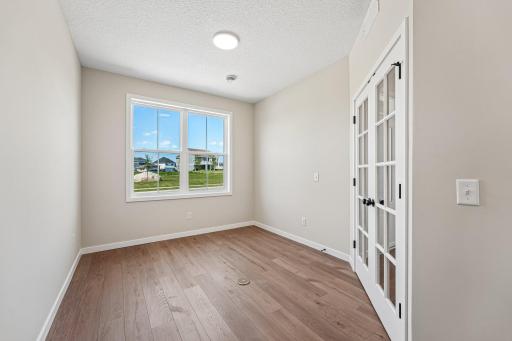 Flex Room with large windows for natural light and beautiful glass doors. Welcome to the Eveleth Patio plan by Robert Thomas Homes. Photos are of similar home; options and features will vary.