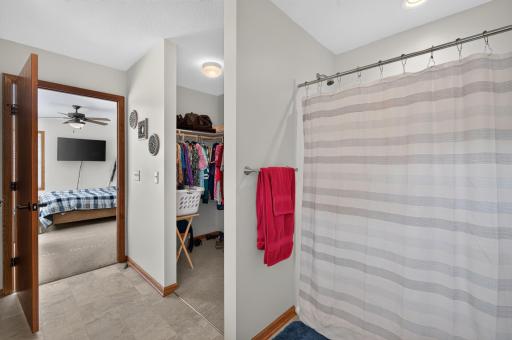 Step-in shower has minimal threshold & adjacent walk-in closet.