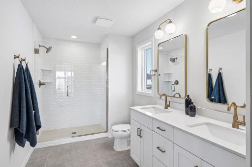 Owner's bath with double vanity and tiled shower. Photos are from similar home; colors, options and features will vary.