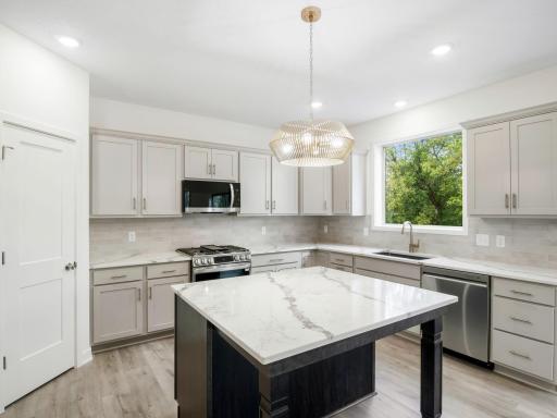 Beautiful light gray perimeter cabinets with stained island and Quartz countertops