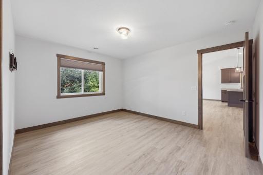Primary bedroom with vinyl flooring, attached bath and walk in closet