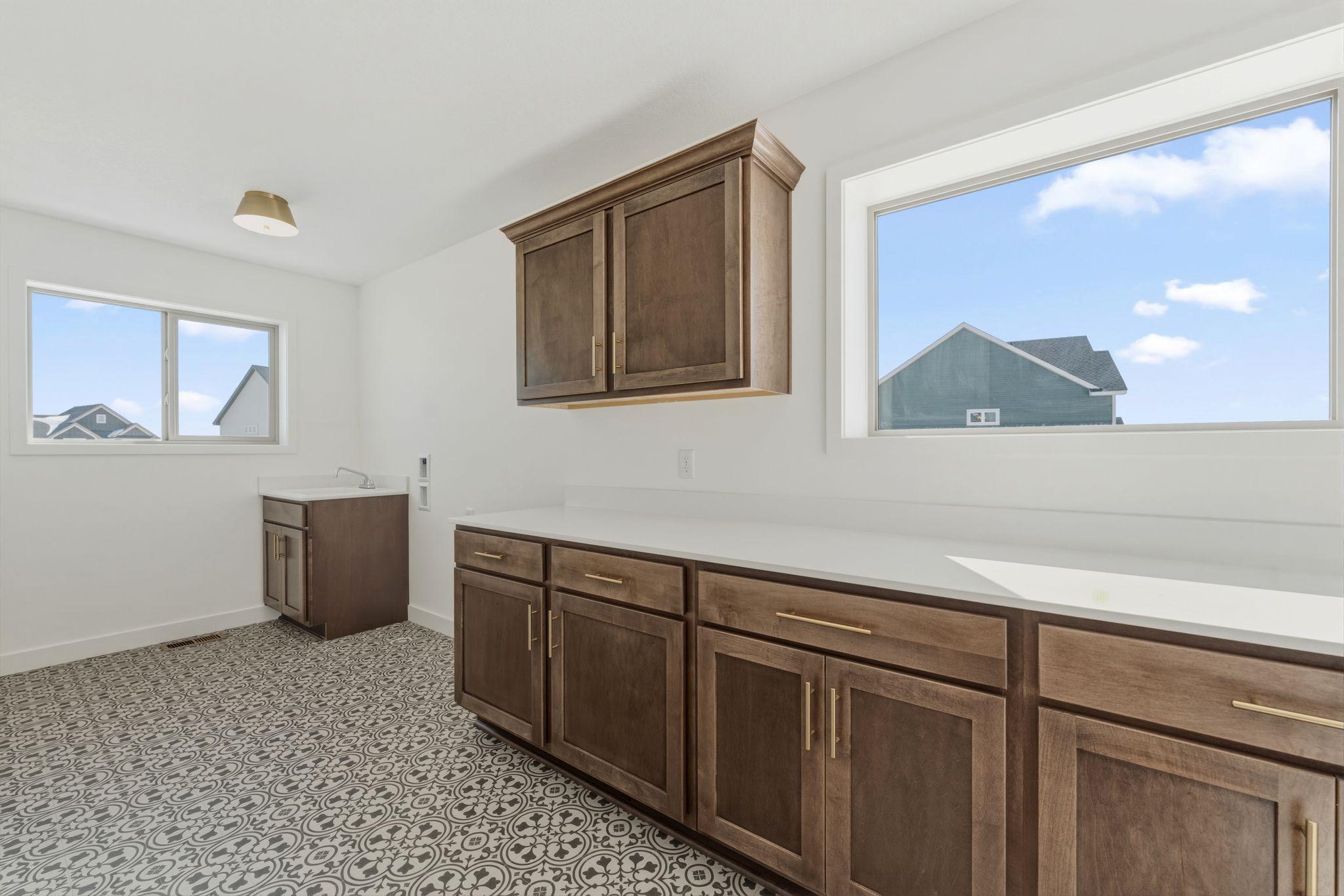 Upper level laundry room with cabinetry