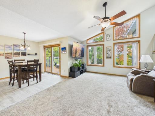 Bright living room with large windows, open sightlines, and a connected dining area.