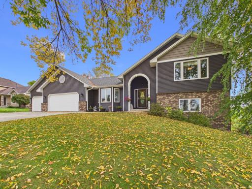 Front exterior of the 4-bedroom New Prague home with mature trees and a wide driveway.