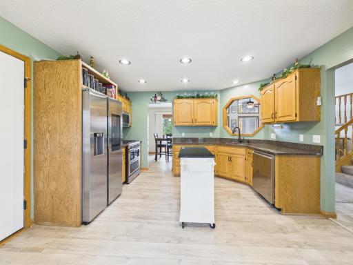 Kitchen with wood cabinetry, granite countertops, stainless steel appliances, and bay window.
