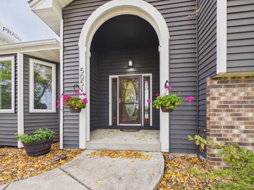 Covered front entry with brick accent and welcoming approach.