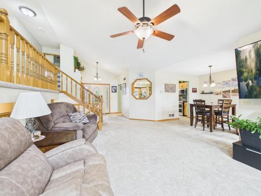 Light-filled living room with large windows and a view toward the kitchen and dining spaces.