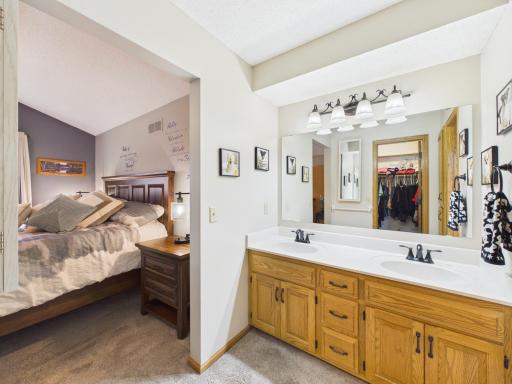 Primary suite bathroom with double-sink vanity and storage.