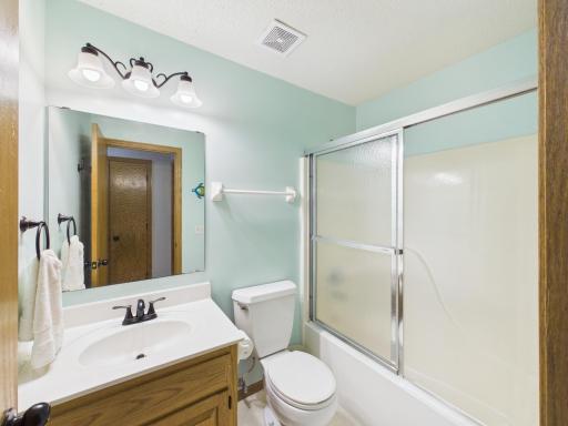 Upper-level full bathroom with vanity, tub, and shower.