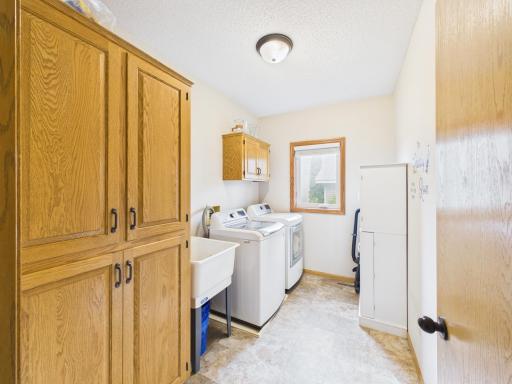 Laundry room with cabinetry, utility sink, and additional storage.