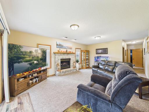 Lower-level family room with fireplace and large window.