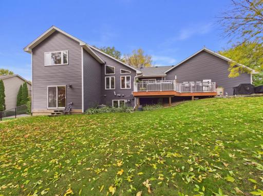 Rear exterior showing the home, deck, lower-level walkout, and backyard.