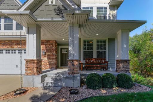 The covered front porch features a seating area bordered by stone pillars and custom rain chains which add a beautiful look, a huge improvement over your traditional gutter.