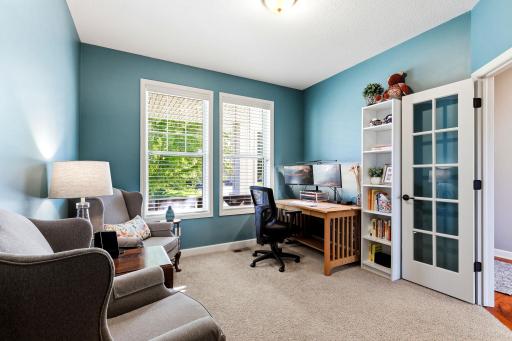 French doors enclose the front office, allowing light to move freely through the space while maintaining privacy for focused work.